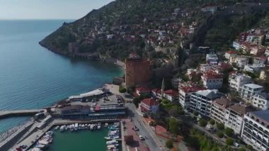 Alanya 'daki kırmızı kuleyi ele geçirin, taş duvarların çarpıcı bir dağ ve deniz manzarasıyla buluştuğu yeri mükemmel bir manzara için..