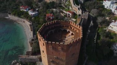 Alanya 'daki antik kırmızı kuleyi ziyaret edin. Taş duvarlar ve panoramik bir dağ manzarası sonsuz bir manzara yaratır..