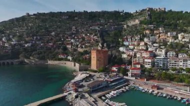 Alanya 'nın deniz kenarındaki kırmızı kulesini deneyin. Taş duvarlar ve güzel bir dağ manzarası mükemmel bir manzara yaratır..