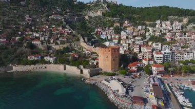 Alanya 'daki tarihi kırmızı kuleyi deneyin. Taş duvarlar, liman manzaraları ve sonsuz dağ ufukları sunuyor..