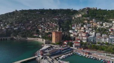 Alanya 'daki kırmızı kuleyi keşfedin, antik taş duvarları, canlı liman sahnelerini ve sakin bir dağ zeminini sergileyin..
