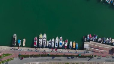Yatlar ve temiz suda küçük tekneler. Manzaralı ve rahatlatıcı bir marinanın hava görüntüleri..