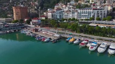 Alanya 'daki kırmızı kuleyi keşfedin, taştan bir mimari harmanı, canlı liman sahneleri, ve sakin dağ manzarası..