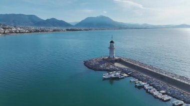 Mavi denizde beyaz deniz feneri. Çarpıcı ve sakin bir hangarın hava görüntüleri..