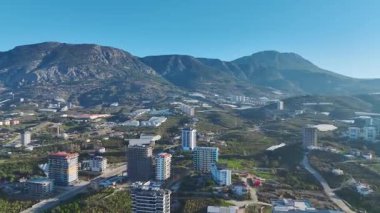 Dağları olan yeşil bir şehir. Manzaralı bir şehir manzarasının hava görüntüleri.