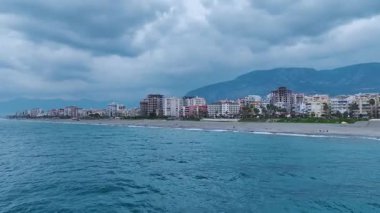 Canlı günbatımı ve şehrin ufuk çizgisi. Büyüleyici bir deniz manzarasının hava görüntüleri.