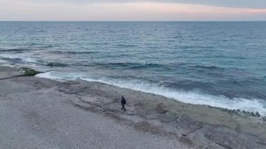 Güneş ışığı, dalga izli kum. Sıcak ve rahatlatıcı bir deniz kenarının hava görüntüleri..