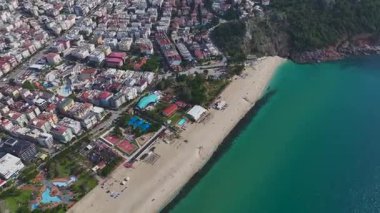 Beyaz kumsal ve kıyı silueti. Deniz manzaralı bir yerin havadan çekilmiş görüntüleri..