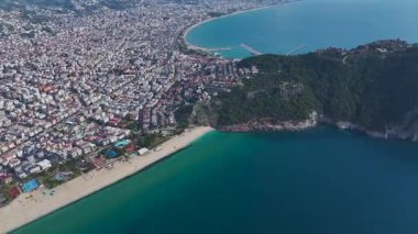 Beyaz kum, şehir manzarası ve açık gökyüzü. Çarpıcı bir sahil inzivasının hava görüntüleri..