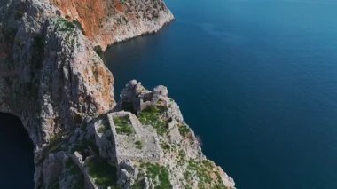 Eski kale ve turkuaz deniz. Manzaralı tarihi bir yerin hava görüntüleri.
