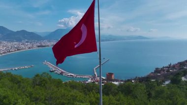 Bayrak ve yeşil manzara. Barışçıl ve vatansever bir ortamın hava görüntüleri..