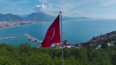 Dağların ve denizin üzerinde bayrak. Büyük doğal ve tarihi bir manzaranın hava görüntüleri..