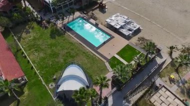 Şehir, sahil ve okyanus dalgaları. Rahatlatıcı ve canlı bir sahil şeridinin hava görüntüleri..