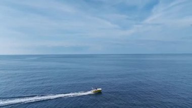 Tekne kıyıya doğru ilerliyor. Güneşli bir sahil sahili görüntüsü..