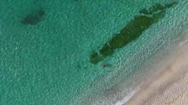 Denizde tek başına yüzüyor. Sakinleştirici ve manzaralı bir anın hava görüntüleri..