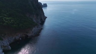 Yeşillik ve kayalık sahil. Barışçıl bir okyanusun hava görüntüleri..