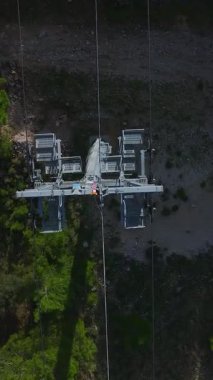 Orman ve denizin üzerinde füniküler. Nefes kesici bir sahil yolculuğunun hava görüntüleri..