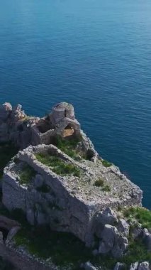 Kale, ağaçlar ve okyanus manzarası. Nefes kesici bir ufuk çizgisinin dikey görüntüsü.