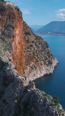 Dağdaki kale. Panoramik bir şehir ve okyanus manzarasının dikey görüntüleri.