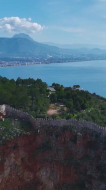 Kale, ağaçlar ve sahil şeridi. Manzaralı ve tarihi bir yerin dikey görüntüleri.