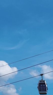 Füniküler ve güneşli bir gökyüzü. Barışçıl bir hava yolculuğunun dikey görüntüleri.