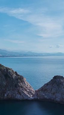 Okyanus kayaları ve dalgalanan dalgalar. Sakin bir denizcinin dikey görüntüsü.