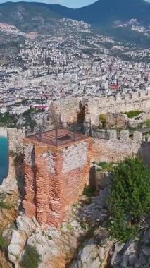 Kale, yeşil manzara ve şehir. Tarihi ve huzurlu bir yerin dikey görüntüsü.