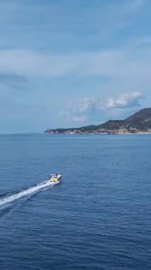 Denizde sürat teknesi. Parlak bir gökyüzünün altında hızlı bir sürüşün dikey görüntüleri.
