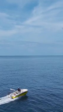 Yüksek süratli tekne yolculuğu. Heyecan verici bir deniz yolculuğunun dikey görüntüleri.