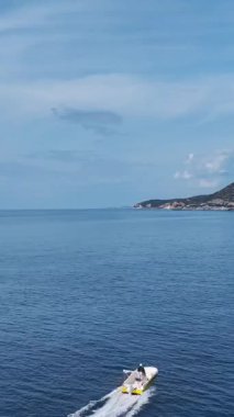 Tekne ve köpüklü deniz. Güzel bir tropikal kaçışın dikey görüntüleri.