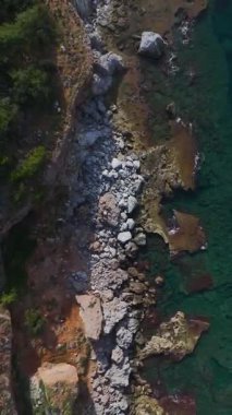 Deniz kenarındaki kaya oluşumları. Doğal bir sahil manzarasının dikey görüntüleri.