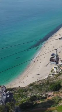 Okyanus manzaralı kablo araba. Beyaz bir sahil boyunca sakin bir sahil yolculuğunun dikey görüntüleri..