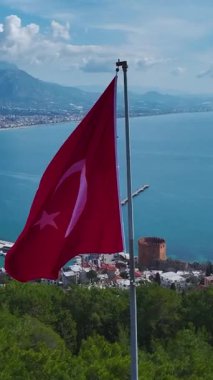Bir tepenin üstünde bayrak. Tarihin ve doğanın çarpıcı hava görüntülerinin dikey görüntüsü.