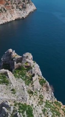 Kıyı kayalığı ve deniz. Ham ve güçlü doğal bir sahnenin dikey görüntüleri.