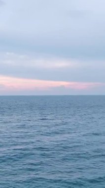 Okyanusun üzerinde gün batımı. Rüya gibi bir akşam deniz manzarasının dikey görüntüsü.