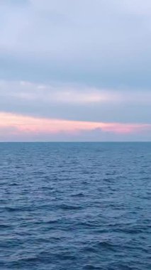 Hava gün batımı ve deniz. Barışçıl ve romantik bir sahnenin dikey görüntüleri.
