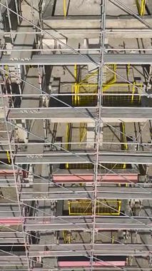 Bina iskeleti ve iskelesi. Çalışan bir inşaat alanının dikey görüntüleri.