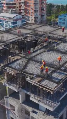 Hava çimento karıştırma ve çelik işçiliği. Dinamik bir inşaat sürecinin dikey görüntüleri.