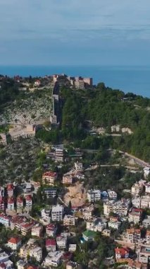 Deniz kenarında bir ortaçağ şatosu. Tarih ve doğanın dikey görüntüleri.