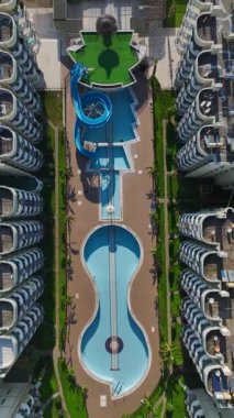 Tatil köyündeki havuz bomboş. Sessiz bir yerleşim yerinin dikey görüntüsü.