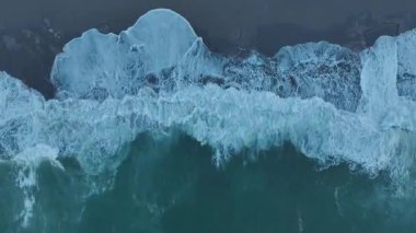 Dalgalar ve köpükler nefes kesici bir sahil şeridi oluşturur..