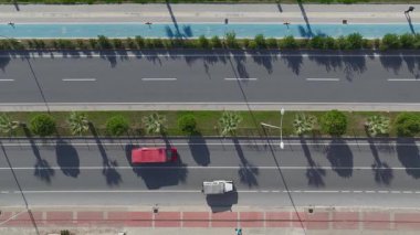 Yol aktivitesi ve deniz manzarasının resimsel bir karışımı.