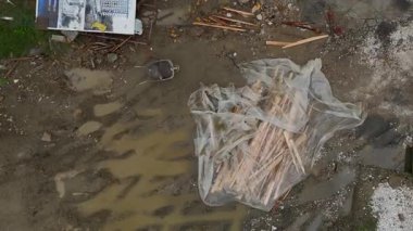 Çamur, aletler ve hurda odunlarla dolu pis bir site..