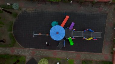 Yetişkinler ve çocuklar salıncaklarda vakit geçiriyorlar..