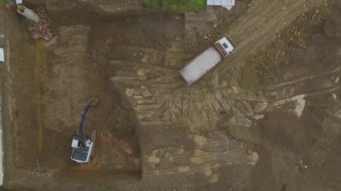 Kazıcı, çöp kamyonunu dolduruyor..