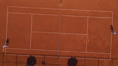 Spor kampında kil yüzeyi üzerinde talim yapan sporcular.