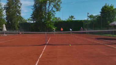 Eğitim sırasında kil sahada yer alan sporcular.