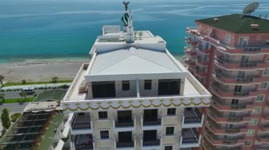 Sahile ve suya bakan apartman balkonunda..