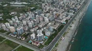 Sakin deniz kıyısında hareket eden araçlar.