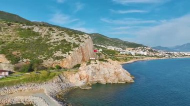 Kayalık arazi ve turkuaz Akdeniz 'le huzurlu bir sahil yolculuğunun insansız hava aracı görüntüsü.